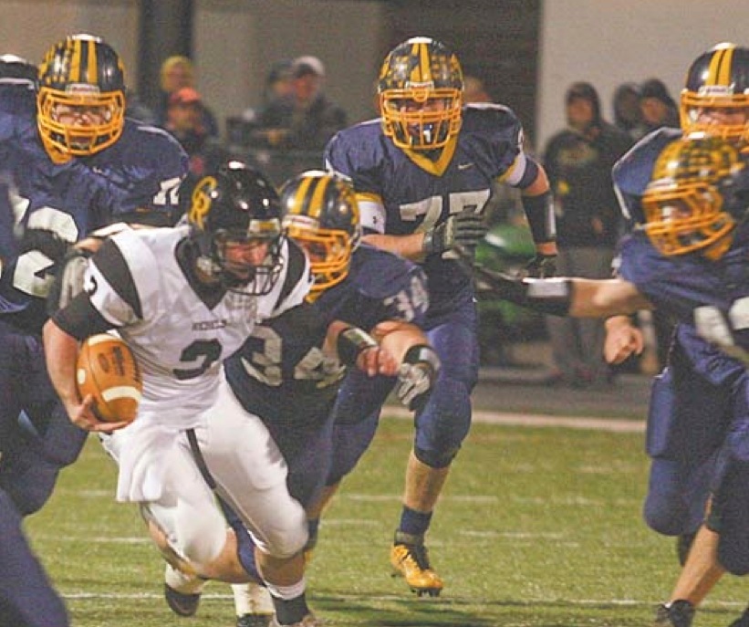 Kirtland defenders swarm Crestview quarterback Adam Coppock during the Division V regional championship game Friday at Mollenkopf Stadium in Warren. The Hornets overwhelmed the Rebels, 35-7.