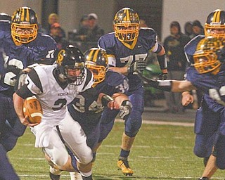 Kirtland defenders swarm Crestview quarterback Adam Coppock during the Division V regional championship game Friday at Mollenkopf Stadium in Warren. The Hornets overwhelmed the Rebels, 35-7.