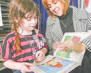 Author Rebecca Macri and Courtney Ross, 7, look over the book that was inspired by the Watson Elementary first-grader.