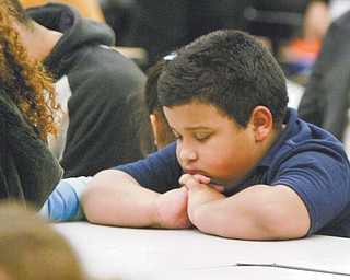 Edwin Rodriguez, a second-grader at Williamson Elementary in Youngstown, gives thanks Monday before a Thanksgiving dinner at the school. Students and their families were treated to the meal after parents attended parent-teacher conferences last week.