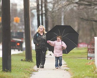 Diane Wagner and Judy Peyatt, her 7-year-old daughter, both of Niles, walk home together in the rain after school on Robbins Avenue. With a month to go, 2011 is already the area’s second-wettest year on record.