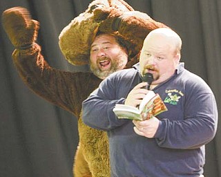 Jim Hixson reads while his brother, Jon, dresses as a squirrel to bring to life a children’s book. The J.J. Brothers visited the Lloyd Elementary School in Austintown Wednesday.