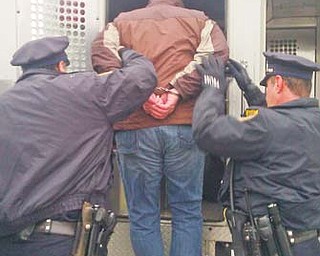 Youngstown police assist a protester into the back of a police van. On Wednesday, protesters held a banner reading “Stop toxic earthquakes” while standing in front of a truck leaving a D&L Energy injection-well site on Ohio Works Drive in Youngstown.