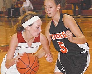 Cardinal Mooney’s Macy Marlowe (4) drives to the hoop against Springfield defender Baylee Felger (5) during
their basketball game Thursday at Mooney High School. The Cardinals downed the Tigers, 49-37, with Marlowe sparking the Cards’ second half with a coast-to-coast lay-up after an early steal in the Springfield paint.