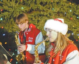 Austintown Fitch High School band members Jeremy Eyster and Amanda Lacusky play Christmas carols before the 25th annual Christmas-tree lighting at Wickliff e Circle Fire Station in Austintown. Several hundred residents enjoyed music, cookies and a visit from Santa on Thursday evening.