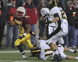 Mooney #10 Justus-Ellis Moore is tackled by #11 Shawnee Grant Miller and #23 Drew Young by his shirt. Youngstown Cardinal Mooney won their 8th championship as they beat the Shawnee Braves in Fawcett Stadium 21-14. (AP Photo/The Vindicator, Robert K. Yosay)