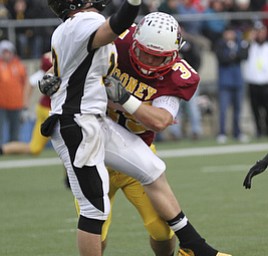 Mooney #35 Anthony Dermotta dislodges the QB for Shawnee Brad Jarzab during second half action. Youngstown Cardinal Mooney won their 8th championship as they beat the Shawnee Braves in Fawcett Stadium 21-14. (AP Photo/The Vindicator, Robert K. Yosay)