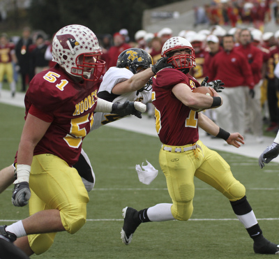 Shawnee #14 Dusty Seelig gets the facemask of PJ Quin as #51 Carmen Lanzo -  they scored on the next play. Youngstown Cardinal Mooney won their 8th championship as they beat  the Shawnee Braves in Fawcett Stadium  21-14. AP Photo/The Vindicator, Robert K. Yosay)
