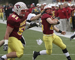 Shawnee #14 Dusty Seelig gets the facemask of PJ Quin as #51 Carmen Lanzo - they scored on the next play. Youngstown Cardinal Mooney won their 8th championship as they beat the Shawnee Braves in Fawcett Stadium 21-14. AP Photo/The Vindicator, Robert K. Yosay)