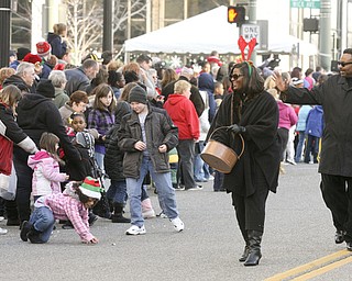 JESSICA M. KANALAS | THE VINDICATOR..Sixth ward council woman Janet Tarpley passes candy out with her fiance, David Portis, during the holiday parade in Downtown Youngstown.