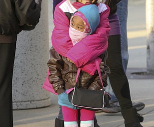 JESSICA M. KANALAS | THE VINDICATOR..Ziyah Rivera, 10, holds her sister, Morgan Jackson, 4, of Youngstown for warmth during the holiday parade in Downtown Youngstown.