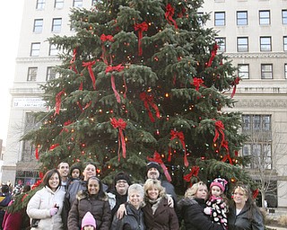 JESSICA M. KANALAS | THE VINDICATOR..Four generations of the Greenwalt family stand in front of the newly lit city tree which they donated. The tree was planted 39 years ago in the front of their Youngstown home.