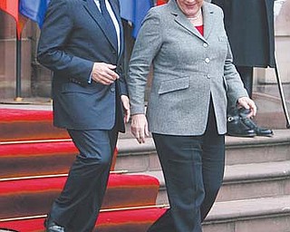 German Chancellor Angela Merkel and French President Nicolas Sarkozy leave the building after their meeting in Strasbourg, France. Sarkozy and Merkel will meet in Paris today to unveil a proposal for closer political and economic ties among the 17 countries that use the euro. Though the leaders diff er on some of the details, their
cooperation has been so tight, they have come to be known by a single name: “Merkozy.”