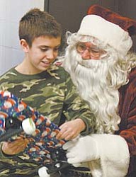 Jacob Burkett, 10, of East Canton, visits Santa at the party for family members of deployed Army National
Guard soldiers in Lordstown.