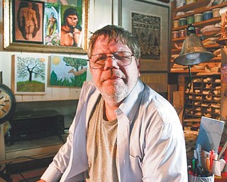 Scott Pergande, above, sits in his art studio in his Youngstown home. Pergande was attacked outside his home in August and lost the vision in his left eye. He will auction art from his collection Sunday to help pay his medical bills.