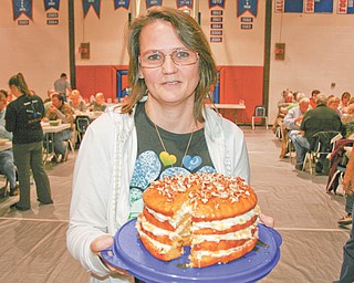 Wanda Wilson of Berlin Center walked away with the Grand Champion title at the Berlin-Ellsworth Ruritan Club’s baking contest last month. Here she shows off the winning entry, her four-layer pumpkin cake.