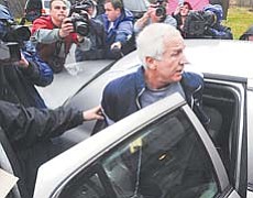 Former Penn State associate head football coach Jerry Sandusky is escorted to a police car Wednesday in Bellefonte, Pa., after being arrested on new child-sex abuse charges brought by two new accusers.