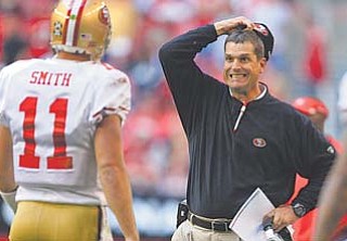 San Francisco head coach Jim Harbaugh grimaces after his offense fails to move the ball as Alex Smith comes off the field during the second quarter of Sunday’s game against Arizona in Glendale, Ariz.