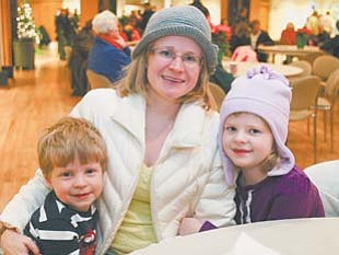 Jan Billock sits with her children, 4-year-old Hayden, left, and 5-year-old Dylan at the Merry Bright Nights event at Fellows Riverside Gardens in Mill Creek Park.