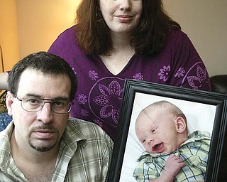 John Gifford and his girlfriend, Heather Olsen, hold a photo of their 4-month-old son, Tyler, in their Austintown home. Gifford is unemployed and is having a difficult time finding work.