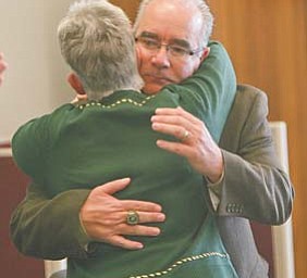 New Ursuline football coach Larry Kempe hugs school principal Patricia Fleming at Monday’s introductory
press conference at Ursuline High School.