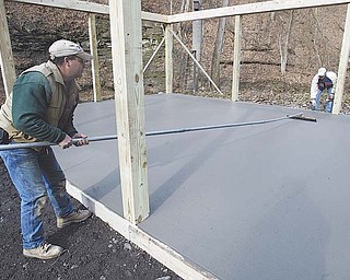 Paolo Ricottilli, left, and his brother, Lee, put the finishing touches on a concrete pad that will be the floor of the new Lowellville School District science lab in Pine Hollow Park. The brothers own Ricottilli Construction of Poland Township.