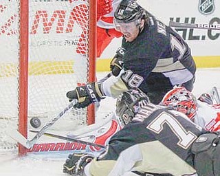 Pittsburgh Penguins’ James Neal (18) and Evgeni Malkin (71) try to get the puck past Detroit Red Wings goalie Jimmy Howard in the second period of a game Tuesday in Pittsburgh. Howard made the saves, and the Penguins did not score.