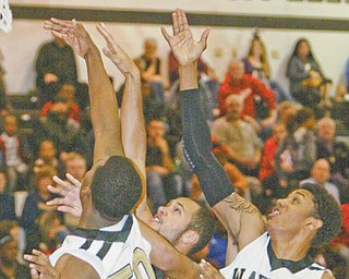 Warren Harding’s Rashid Gaston (50) and Shaheed Davis go for a rebound during Tuesday’s game against Canton McKinley in Warren.