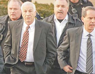 Former Penn State University assistant football coach Jerry Sandusky, second from left, walks with his attorney, Joe Amendola, second from right, as he leaves the Centre County Courthouse in Bellefonte, Pa., on Tuesday.
