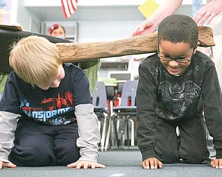 Austin Shanabarger and Nolan Ballard of Watson Elementary School in Austintown try out an oxen yoke as they get a hands-on lesson about pioneer life. Ester Hallaman, volunteer with the Arms Family Museum of Local History, is sharing a story and artifacts during her two-day visit to the school.