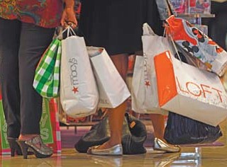 Shoppers stop to look at a display at Dadeland Mall in Miami. Americans spent more on autos, furniture and clothing last month as retail sales rose for the sixth-straight month.