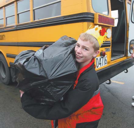 Sixth-grader Danny Moore, a Crestview student, takes a bag from the Springfield bus during the two schools’ annual holiday project.