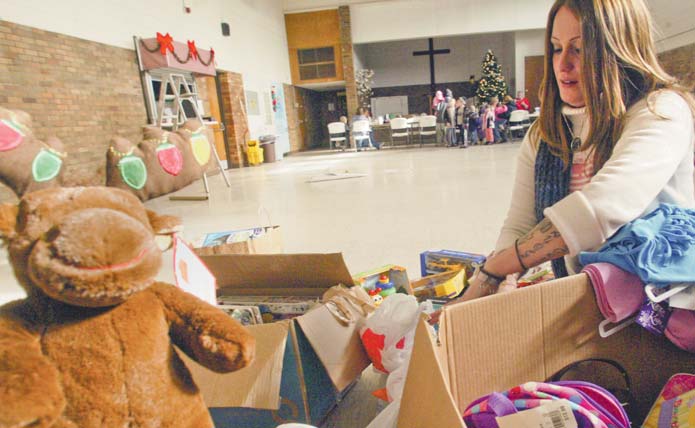 Mindy Jones, a volunteer at the Warren Family Mission on Elm Road, sorts through toys for needy children.