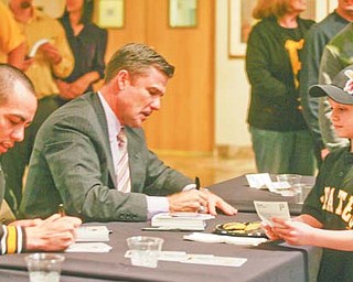 Pittsburgh Pirates pitcher Jeff Karstens, left, and team president Frank Coonelly sign autographs for Ramsey Brown, 7, of Sharon, Pa., at the annual Pirates Caravan event Wednesday at The Butler Institute of American Art in Youngstown. Normally reserved for the end of January, the annual event was moved up a month because the team was itching to get the season going, said Coonelly.