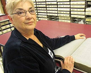 Diana Marchese, Trumbull County recorder, stands with a 100-year-old index book for property deeds at the recorder’s office. The book is an example of the good condition they are in now, and Marchese hopes they will stay that way. But she expects the title searchers who use them to increase in number in the weeks to come, as about 80,000 Trumbull County acres are leased at once for shale drilling.