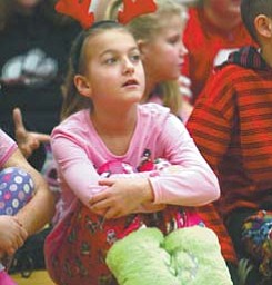 Heike Kaurschill, a Struthers Elementary School third-grader, waits for Santa in her pajamas. All of the school’s 700 students dressed in pajamas Thursday. When Santa arrived at the back door of the auditorium, he made his entrance to deafening cheers and enthusiastic choruses of “Here Comes Santa Claus.”