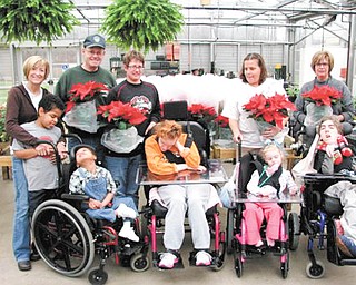 John Schinker of the Men’s Garden Club of Youngstown is shown in the back row, second from left, along with some staff members and clients of the MCBDD Leonard Kirtz School in Youngstown. The club presented 125 poinsettias to the clients of the school, hoping to spread a little extra holiday cheer.