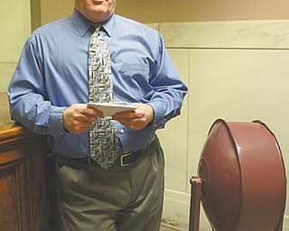 Robert G. Jackson, jury commissioner of Mahoning County Common Pleas Court, holds attendance cards for current jurors. Next to him is the spinning drum used to select jurors for trial panels before the process was computerized about 10 years ago.