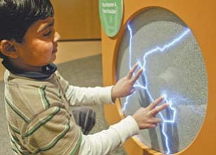 Tayyib Gill, 5, of Columbus, checks out an exhibit at OH WOW!, 11 W. Federal St., which opened in downtown Youngstown in May and showcases many science and technology features. He took part in the tour. Offi cials expect it to become an annual event.