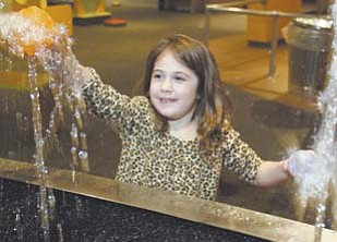 Katie Toepfer, 6, of Howland, tries to place a plastic ball on a stream of water at OH WOW! She was one of more than 150 visitors to the children’s science center and Youngstown Business Incubator during the first Y-Town Tech Tour on Monday.