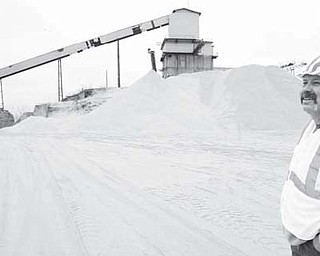 R.W. Sidley Co. owner Rob Sidley stands in front of a pile of crushed, rare conglomerate silica sand that can be processed into a wide variety of products including silica sand used to frack wells.