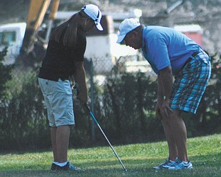 Haleigh Guerrero gets advice from Coach Hutchison at Avalon South Golf Course.
