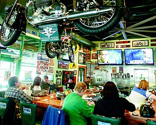 Patrons enjoy drinks and wings at the bar inside the new Quaker Steak and Lube in Boardman. The establishment, which moved from Market Street to its new site last August, was one of eight locations to open in 2011. The Sharon, Pa.-based business looks to open another 12 restaurants this year.