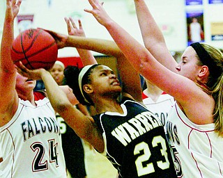 Fitch’s Maura Bianco (24) and and Cassie Custer, right, try to shut down Harding’s Audreyanna Baldridge (23) during the first half of a basketball game Monday at Austintown Fitch High School. The Raiders dominated the Falcons, 72-42.