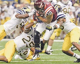 Virginia Tech wide receiver D.J. Coles (18) runs between Michigan cornerback Courtney Avery (5), linebacker Kenny Demens (25) and safety Thomas Gordon (30) during the first quarter of the Sugar Bowl in New Orleans on Tuesday. Michigan won 23-20 in overtime.