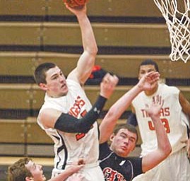 Howland’s Chris Maze goes for two points past Struthers’ Jake Jacubec, left, and Dylan Schmidt during first half action Tuesday at Howland.