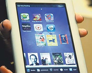 In this photo provided by Barnes & Noble, a demonstrator holds the new Nook Tablet in New York. Barnes & Noble said Thursday it is reviewing its options for its growing Nook e-book reader business and might spin it off from its core bookstore business.