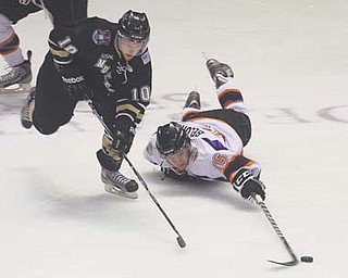 Phantoms forward Ryan Belonger (16) tries to keep Muskegon’s Matt DeBlouw from the puck during Thursday’s game at the Covelli Centre.