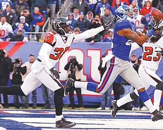 New York Giants wide receiver Mario Manningham, a graduate of Harding High School, pulls in a 27-yard touchdown pass against Atlanta Falcons strong safety James Sanders (36) and Dunta Robinson during the second half of their wild card playoff game Sunday.