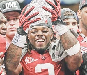 Alabama’s Trent Richardson holds up the winning trophy after the BCS National Championship game against LSU
on Monday in New Orleans. Alabama won 21-0. Commissioners, who met Tuesday, are considering big changes to the BSC, including a playoff .